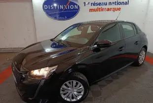 Peugeot 208 noire vue en 3/4 avant droit avec phares allumés, dans un showroom intérieur.