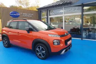 Citroën C3 Aircross Spicy Orange vue 3/4 avant droit, avec barres de toit et jantes distinctives noires et argentées.