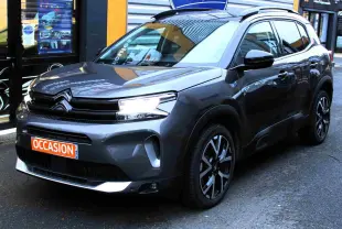 SUV Citroën C5 Aircross gris platinium en 3/4 avant droit, avec jantes noires et phares allumés, affichant un panneau "Occasion".