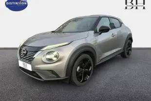 Nissan Juke 1.6 Hybrid Tekna 2025 gris perle métallisé, vue 3/4 avant avec jantes noires distinctives.