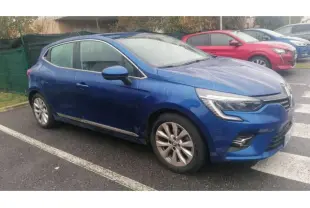 Renault Clio 2021 Bleu Iron vue de profil côté gauche, garée sur un parking extérieur par temps humide.