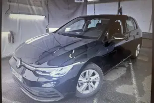 Volkswagen Golf noir intense nacrée vue 3/4 avant droit dans un garage avec jantes alu simples.