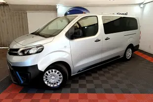 Vue côté droit 3/4 avant d'un Toyota Proace Verso gris clair avec vitres arrière teintées et jantes acier.