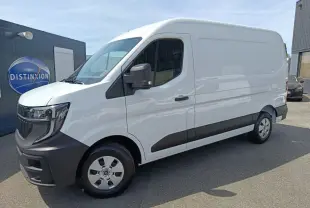 Renault Master blanc en vue 3/4 avant droit, avec pare-chocs et bas de caisse noirs, stationné devant un bâtiment.