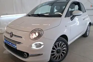 Vue 3/4 avant droite d'une Fiat 500 blanche 2022 avec phares allumés et jantes multibranches distinctives.