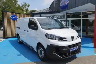 Peugeot Expert Fourgon blanc en 3/4 avant droit, avec calandre noire et logo Peugeot visible, stationné devant un bâtiment.