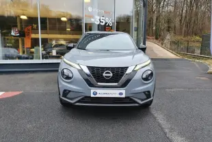 Nissan Juke gris céramique vue de face, mettant en valeur sa calandre en V et ses phares ronds distinctifs.