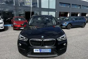 Vue avant d’un BMW X1 20D noir métal, avec calandre double haricot et phares LED visibles sur un parking extérieur.