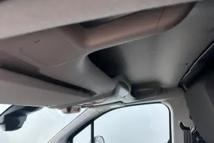 Vue 3/4 avant droite du Citroën Berlingo blanc Icy avec calandre noire et jantes tôle grises, devant un bâtiment Distinxion.