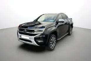 Volkswagen Amarok V6 noir en 3/4 avant droit, avec jantes alu 21 pouces et barres de toit visibles.