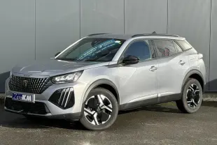 Peugeot 2008 Hybrid 145 e-DSC6 Allure gris Artense en 3/4 avant droit, avec jantes alliage et barres de toit noires.