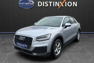 Audi Q2 gris aluminium en 3/4 avant droit, avec calandre noire et jantes alliage 5 branches visibles.