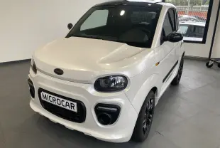 Microcar Dué Must DCI blanc nacré vu en 3/4 avant droit avec jantes noires bicolores et calandre noire.
