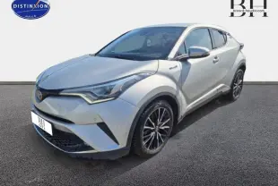 Toyota C-HR gris aluminium vu en 3/4 avant droit, avec jantes alliage et lignes anguleuses distinctives.