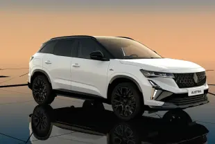 Renault Austral blanc nacré avec toit noir en vue 3/4 avant, soulignant ses jantes noires et calandre distinctive.