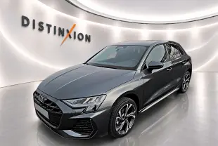 Audi A3 Sportback gris Daytona vue 3/4 avant droit dans un showroom lumineux avec jantes alu graphiques.