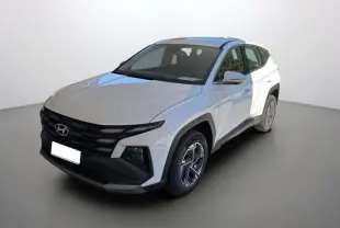 Hyundai Tucson blanc atlas en 3/4 avant droit, avec calandre noire distinctive et jantes alu 17 pouces.