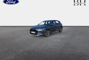 Ford Focus 1.0 Flexifuel bleu azur métallisé vue 3/4 avant droit sur sol gris, calandre noire et jantes alu.