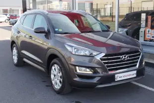 Vue 3/4 avant droit d'un Hyundai Tucson gris Micron 2019 avec calandre chromée et feux LED allumés.
