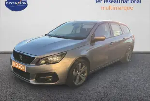 Peugeot 308 SW gris Artense métal vue 3/4 avant droit, avec jantes alliage et calandre noire distinctive.