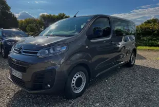 Vue 3/4 avant droite d'un Citroën Jumpy Spacetourer gris foncé 2022 avec jantes acier et 9 places.