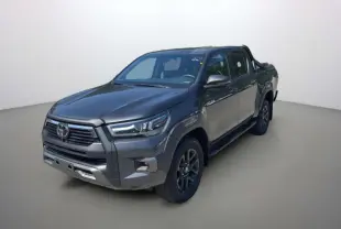Toyota Hilux 4x4 gris atlas en 3/4 avant droit avec arceaux et rideau coulissant manuel sur la benne.