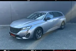 Peugeot 308 gris clair vue 3/4 avant droit, avec feux LED verticaux distinctifs et calandre noire.