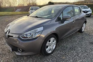 Renault Clio IV gris vue 3/4 avant droit sur parking gravillonné, avec jantes alliage et phares distinctifs.